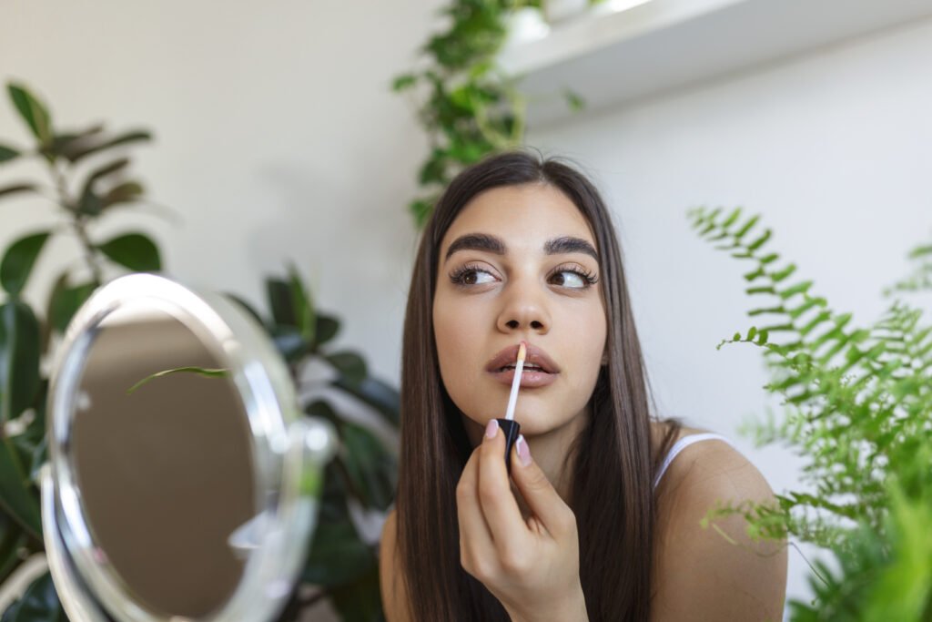 a girl apply lipstick