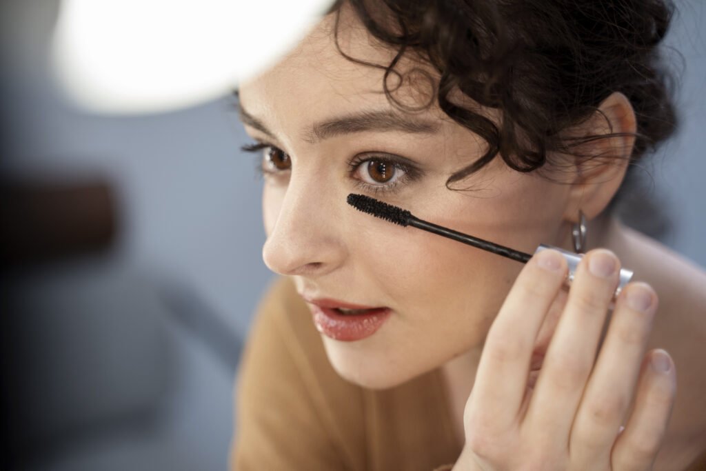 a girl applying mascara