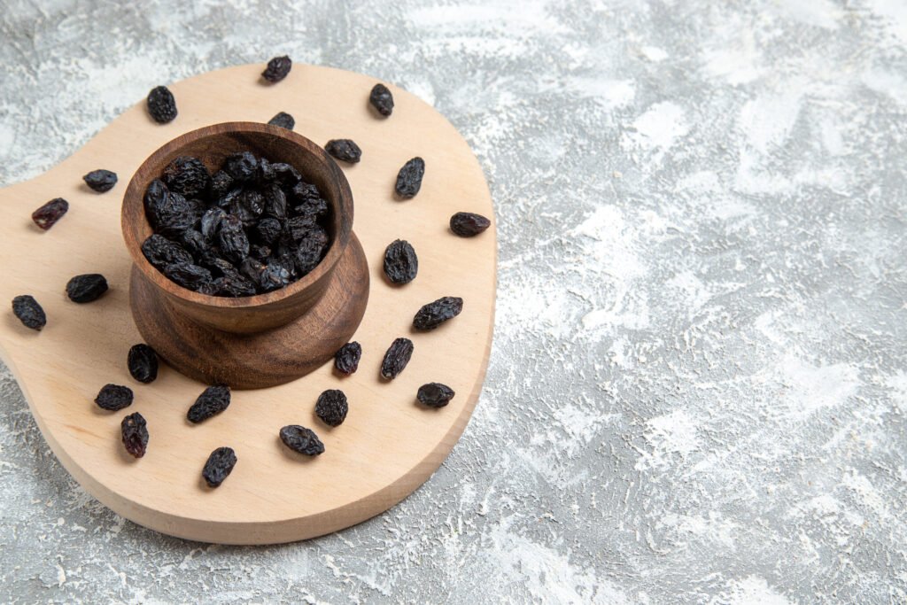 front-view-dried-black-raisin-white-space